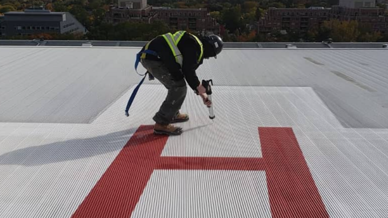 Working at the top of Sunnybrook Hospital, meticulously sealing joints around the helipad to ensure structural integrity and weatherproofing for this critical area.